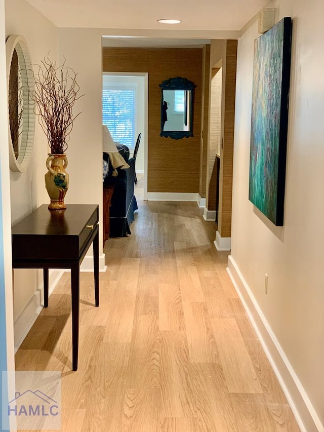 hallway with light wood-type flooring and baseboards