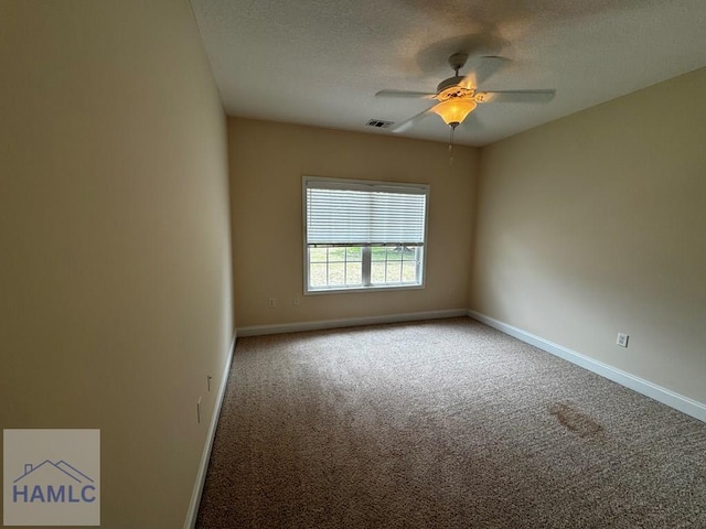 carpeted empty room with visible vents, a ceiling fan, baseboards, and a textured ceiling