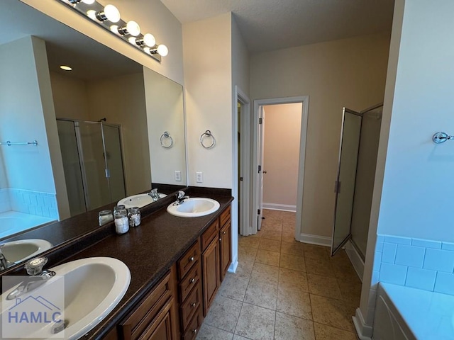 full bathroom featuring a sink, double vanity, a stall shower, and a bath