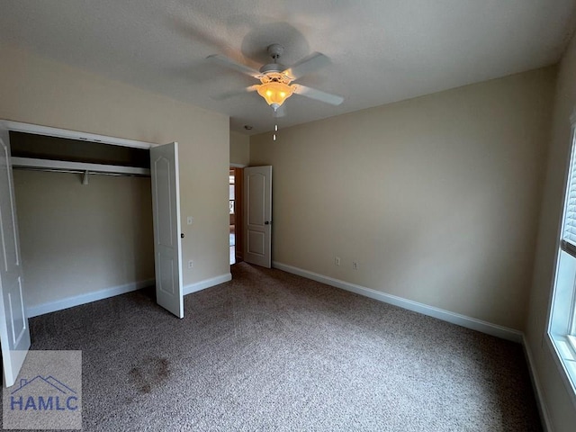 unfurnished bedroom with baseboards, carpet flooring, ceiling fan, and a closet