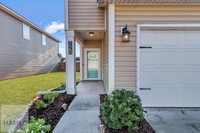 property entrance with a lawn and a garage