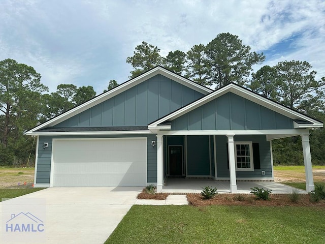 view of front of home featuring a front lawn, covered porch, and a garage