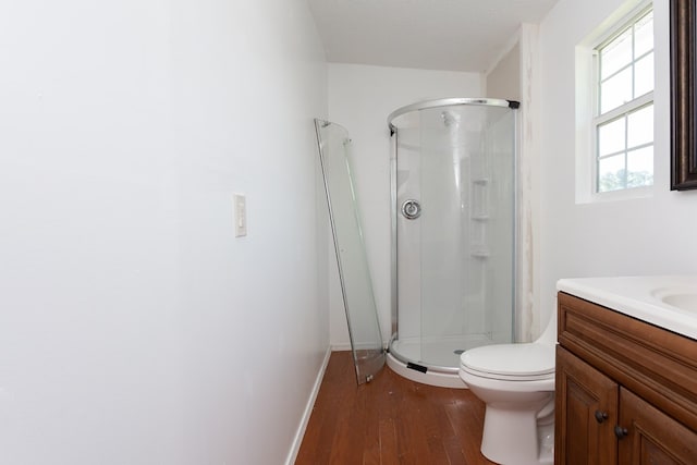 bathroom with hardwood / wood-style floors, vanity, toilet, a textured ceiling, and an enclosed shower