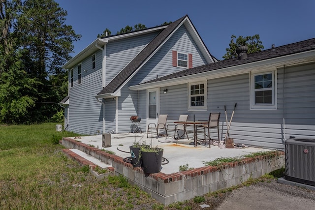 back of house with central air condition unit, a yard, and a patio