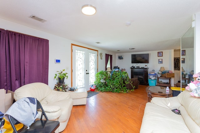 living room featuring french doors, a textured ceiling, and hardwood / wood-style flooring