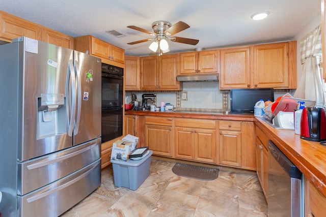 kitchen with ceiling fan, stainless steel appliances, tasteful backsplash, wooden counters, and a textured ceiling