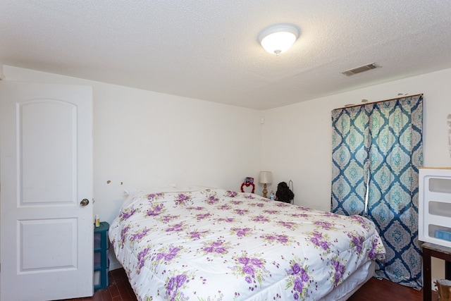 bedroom featuring a textured ceiling and dark wood-type flooring