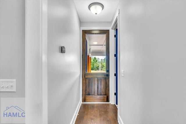doorway to outside featuring baseboards and wood finished floors