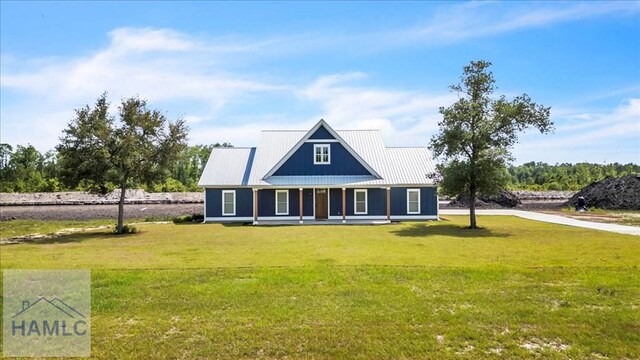 view of front of property featuring a front lawn and metal roof
