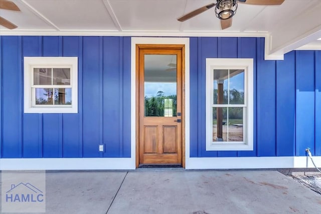 property entrance featuring board and batten siding and a ceiling fan