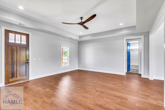 entrance foyer featuring a ceiling fan, wood finished floors, baseboards, a raised ceiling, and recessed lighting