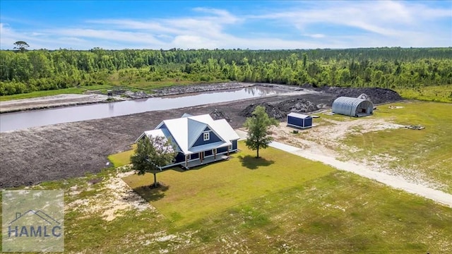 drone / aerial view of a heavily wooded area and a nearby body of water