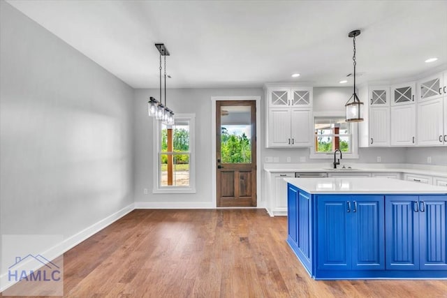 kitchen featuring blue cabinetry, light countertops, white cabinetry, healthy amount of natural light, and recessed lighting