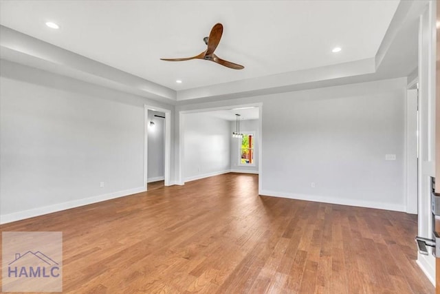 unfurnished living room with wood finished floors, a ceiling fan, baseboards, and recessed lighting