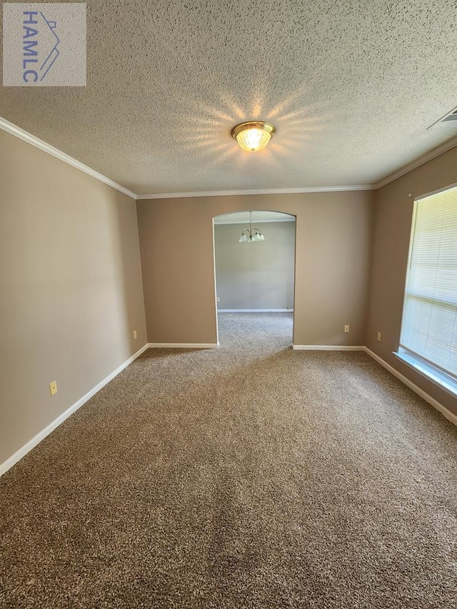 empty room featuring a chandelier, carpet, crown molding, arched walkways, and baseboards