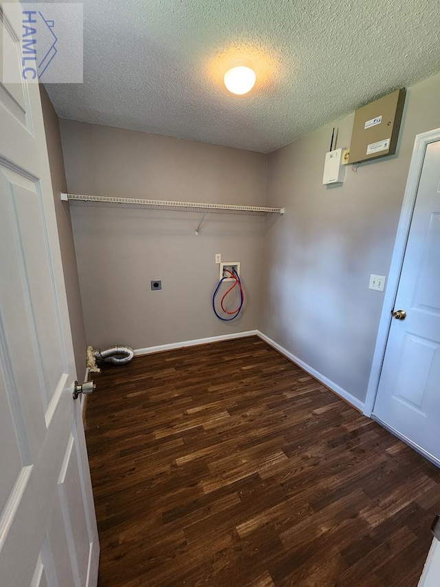 clothes washing area featuring hookup for an electric dryer, wood finished floors, hookup for a washing machine, a textured ceiling, and baseboards