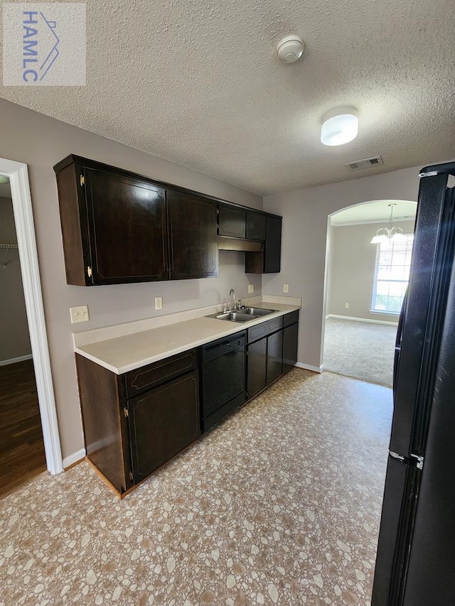 kitchen featuring black appliances, a sink, light countertops, baseboards, and a textured ceiling