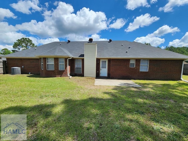 back of house featuring a patio area, brick siding, a chimney, and central AC unit