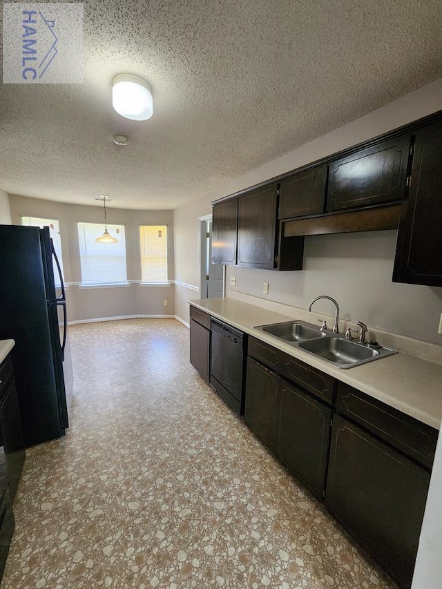 kitchen featuring black appliances, a sink, light countertops, baseboards, and a textured ceiling