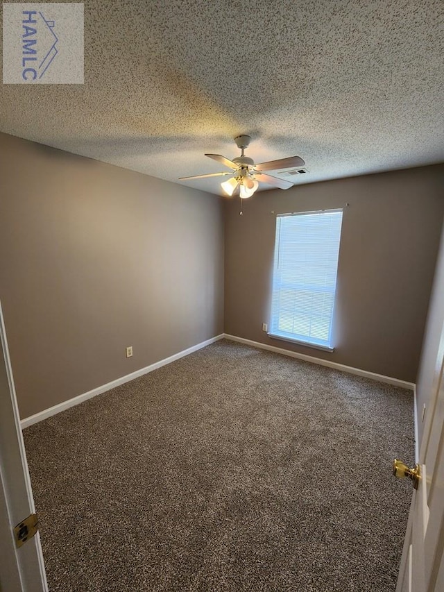 spare room with ceiling fan, carpet, baseboards, and a textured ceiling