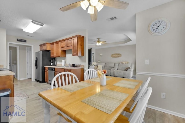 dining space with a textured ceiling, ceiling fan, light hardwood / wood-style floors, and sink