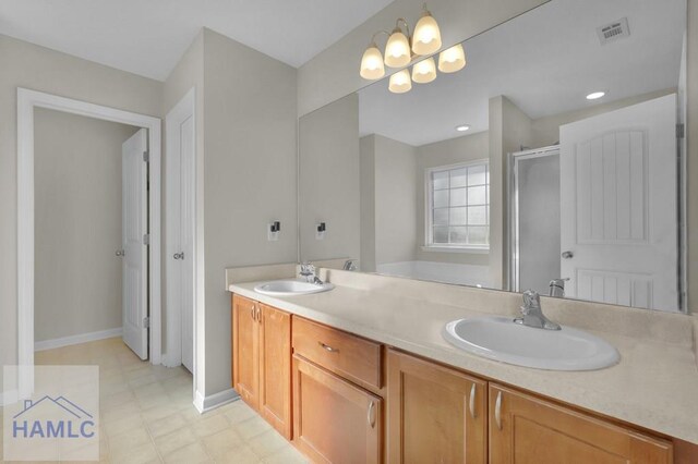 bathroom with vanity, a shower with shower door, and a chandelier