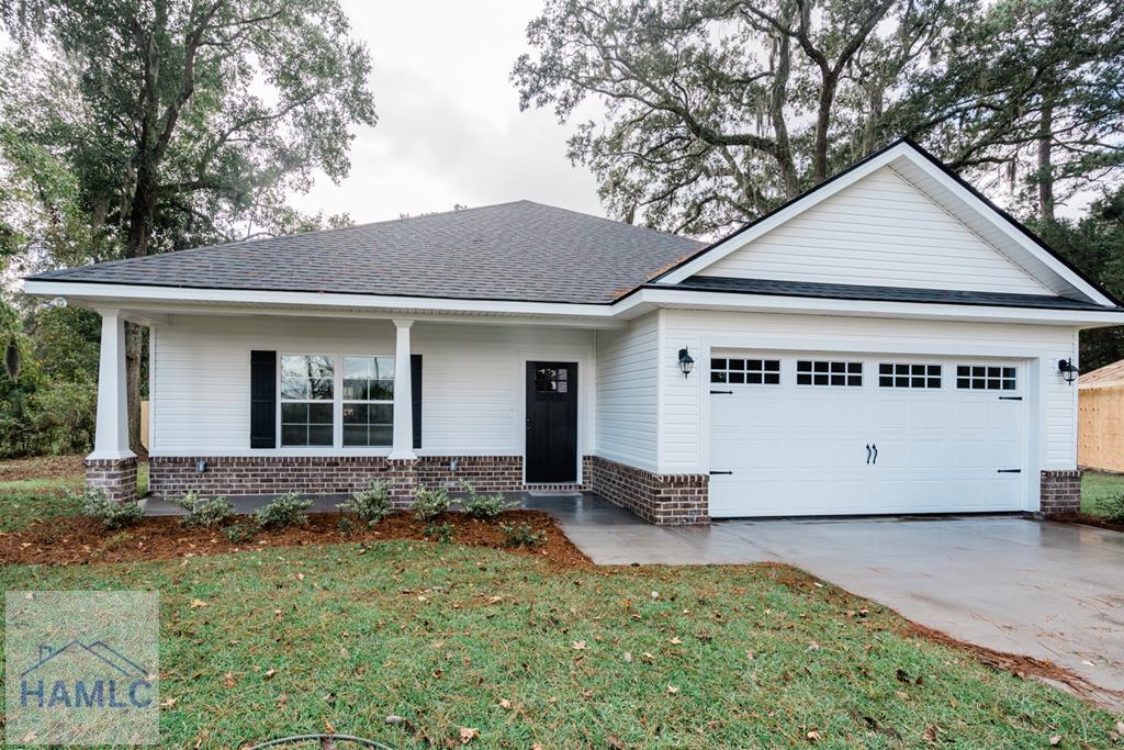 single story home featuring a garage and a front lawn