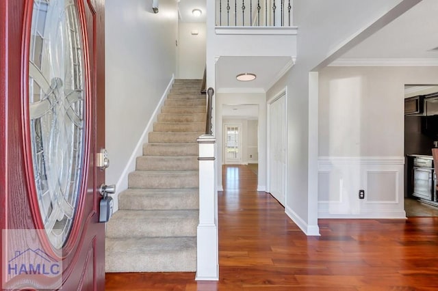 foyer featuring crown molding and dark wood-type flooring