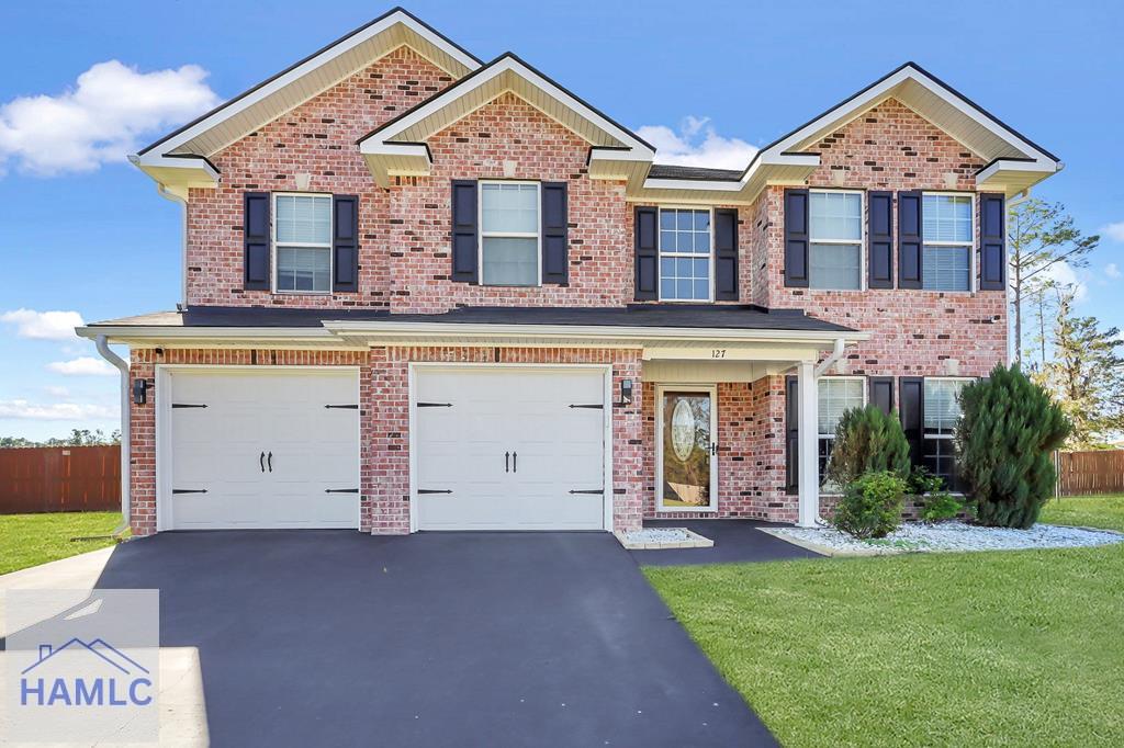 view of front of home with a garage and a front lawn