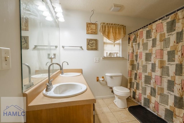 bathroom featuring vanity, toilet, tile patterned flooring, and a textured ceiling