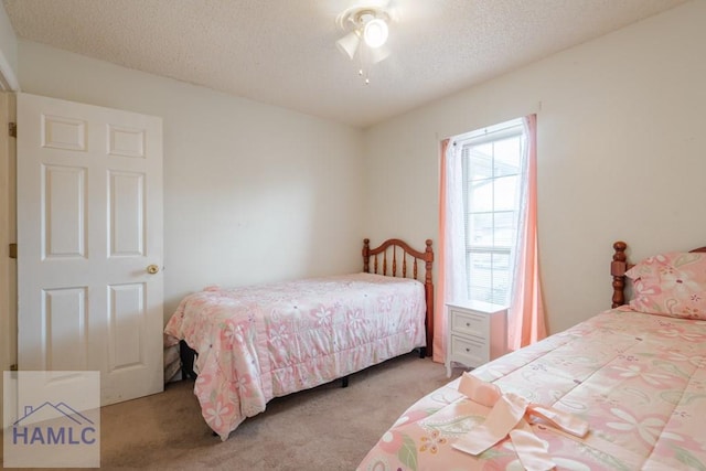 carpeted bedroom with ceiling fan and a textured ceiling