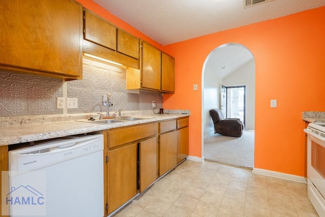 kitchen featuring lofted ceiling, sink, a textured ceiling, white appliances, and decorative backsplash