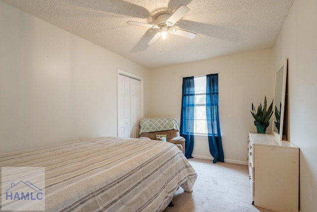 carpeted bedroom featuring ceiling fan, a textured ceiling, and a closet