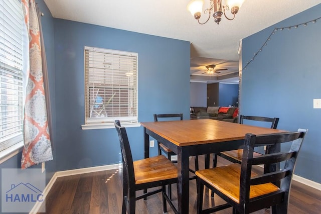 dining area featuring hardwood / wood-style flooring and ceiling fan with notable chandelier