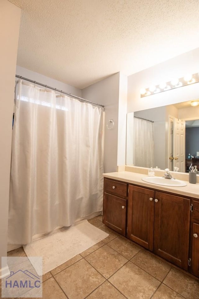 bathroom featuring vanity, tile patterned floors, and a textured ceiling