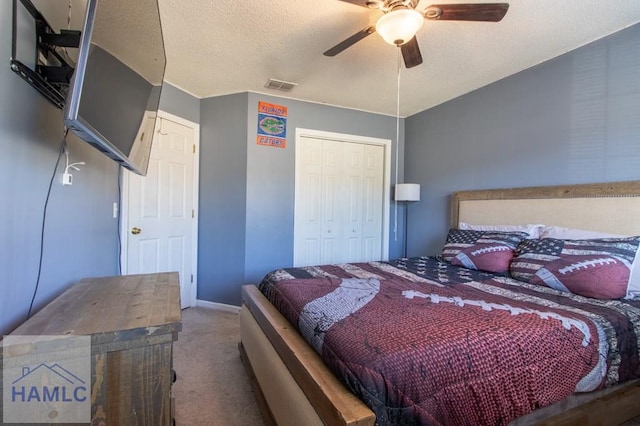 carpeted bedroom with ceiling fan, a textured ceiling, and a closet