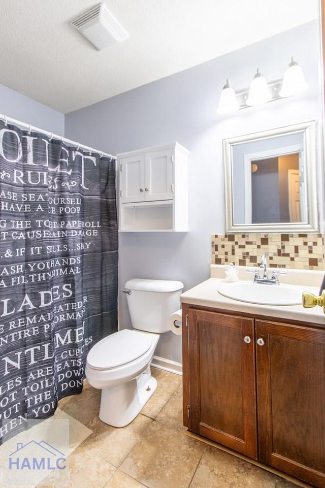 bathroom featuring tile patterned floors, toilet, a textured ceiling, vanity, and backsplash