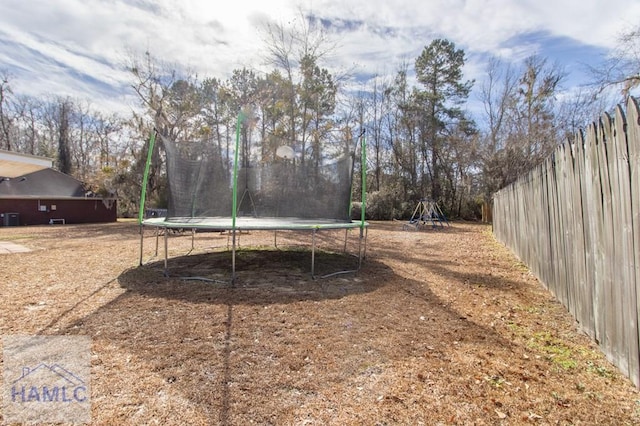 view of yard featuring a playground and a trampoline