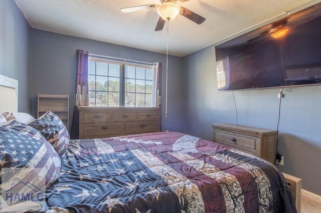 bedroom with ceiling fan, carpet floors, and a textured ceiling