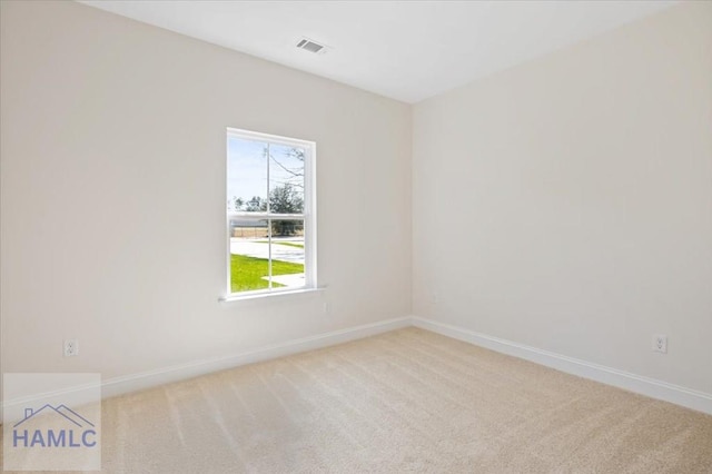 unfurnished room with baseboards, visible vents, and light carpet