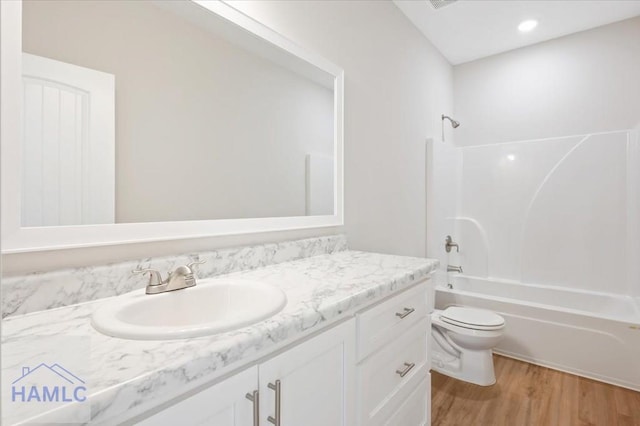 full bathroom with shower / bath combination, toilet, wood finished floors, and vanity