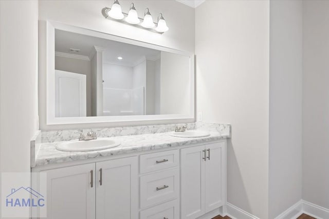 bathroom featuring a sink, baseboards, a shower, and double vanity