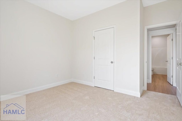 unfurnished bedroom featuring baseboards and carpet