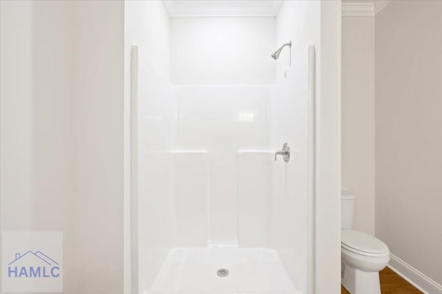 full bathroom with a shower, toilet, wood finished floors, and crown molding