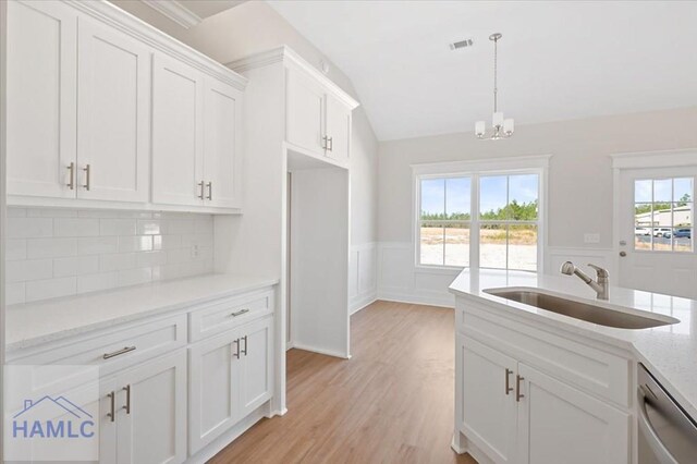 kitchen with visible vents, dishwasher, wainscoting, white cabinetry, and a sink