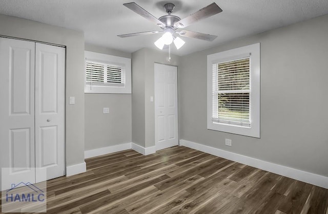123 2nd Ave, Midway, GA 31313 - unfurnished bedroom with multiple windows, dark wood-style floors, a ceiling fan, a closet, and a textured ceiling