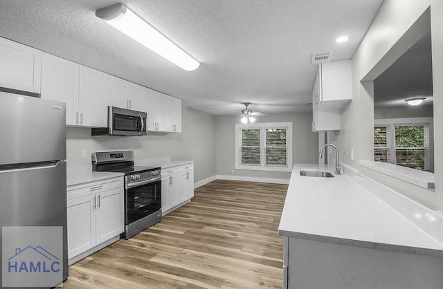 123 2nd Ave, Midway, GA 31313 - kitchen with stainless steel appliances, light countertops, a ceiling fan, light wood finished floors, and a textured ceiling