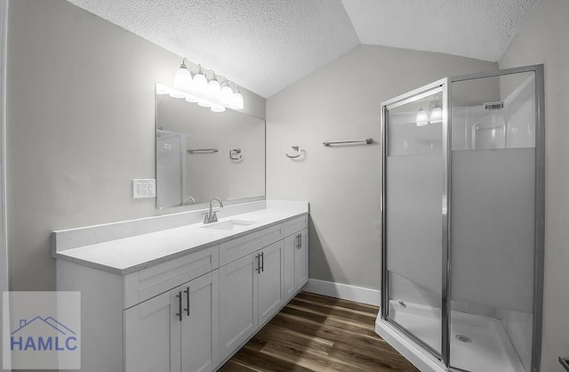 123 2nd Ave, Midway, GA 31313 - bathroom featuring a textured ceiling, lofted ceiling, vanity, a shower stall, and wood finished floors