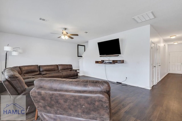 living area with visible vents, baseboards, dark wood finished floors, and a ceiling fan