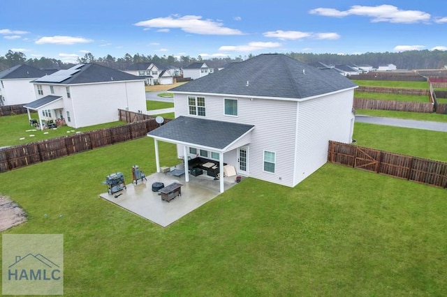 back of property with a yard, a residential view, a shingled roof, and a patio area